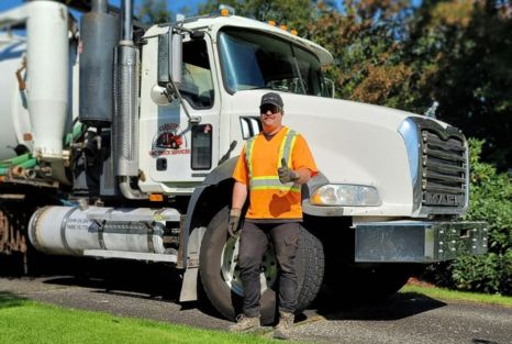 Clearset technician in high-visibility safety gear beside the service truck.